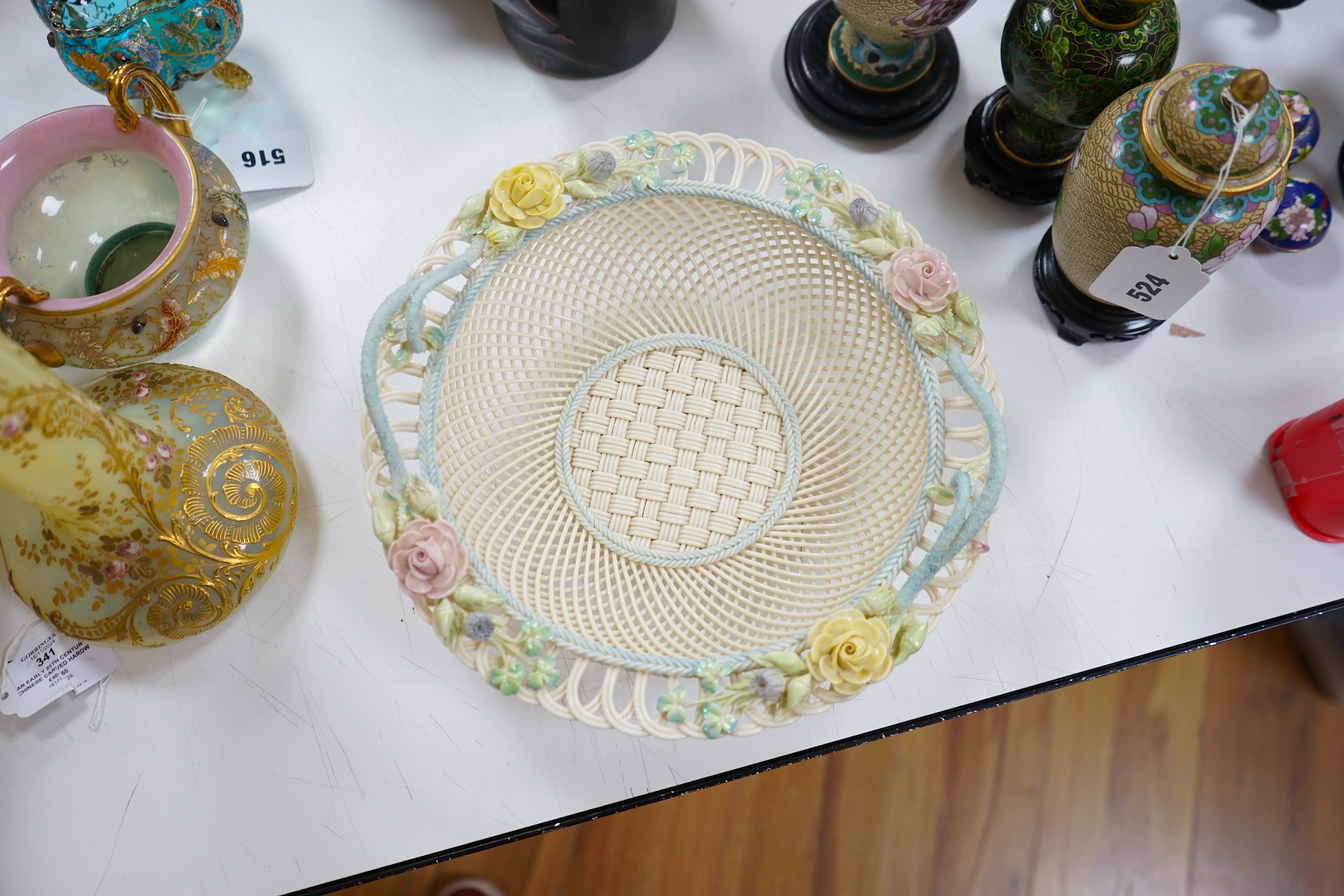 A boxed Belleek coloured basket, 28cm diameter. Condition - fair to good, some damage and wear to the box.